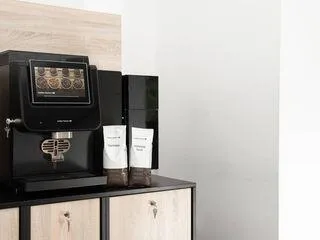 Milchpulver neben einem Kaffeevollautomaten