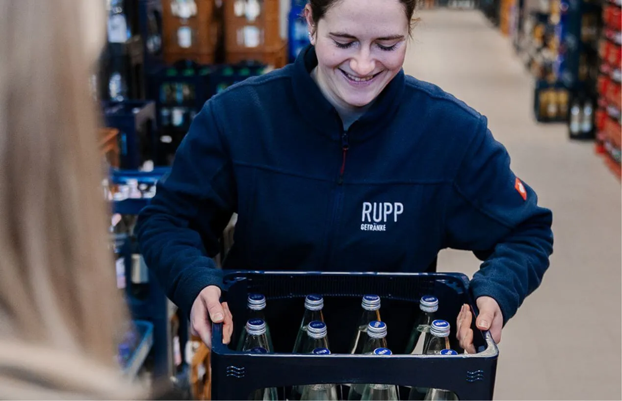 Mitarbeiterin von Rupp Getränke mit einer Wasserkiste