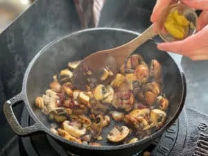 Mittelscharfer Senf wird unter die Zwiebel-Champignon-Mischung gerührt