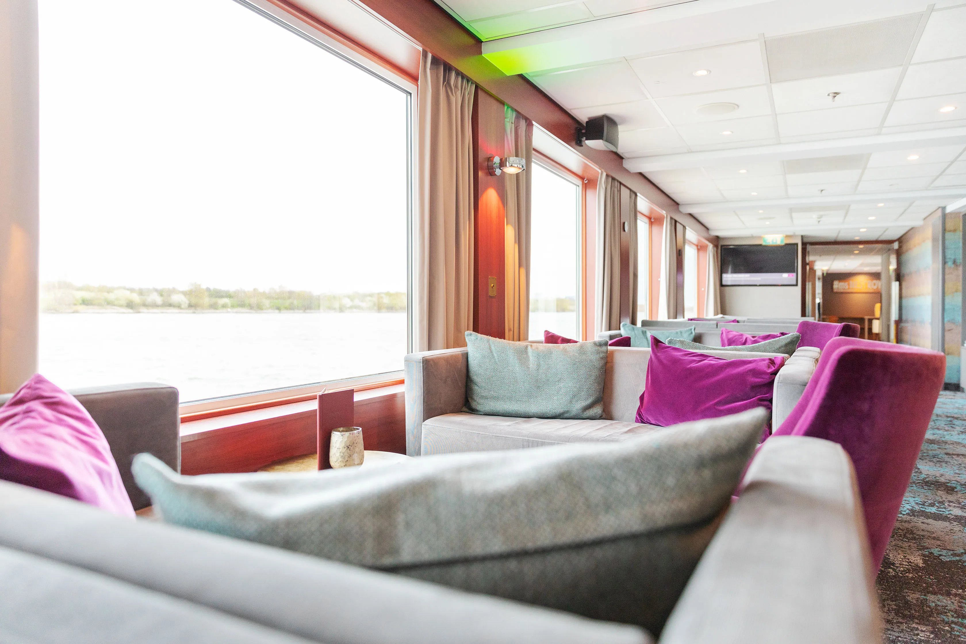 Moderne Panoramalounge und Bar der MS Nestroy mit komfortablen Sitzgelegenheiten für Ihre Donaureise