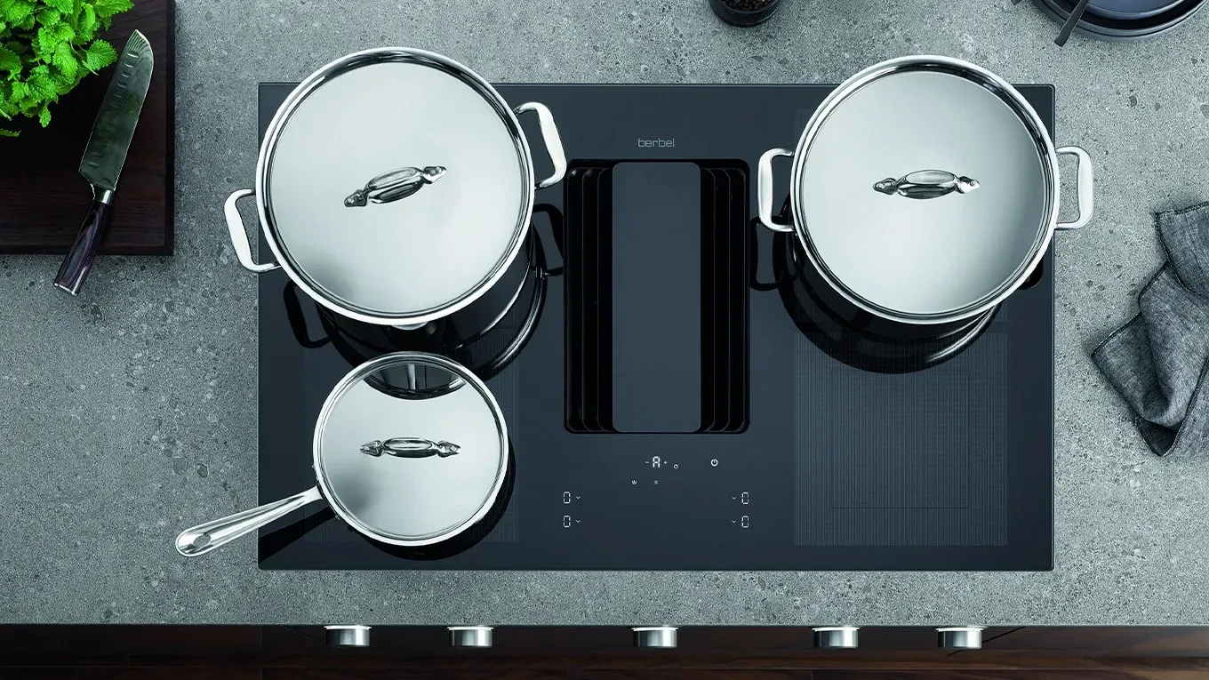 Modernes Kochfeld mit integriertem Dunstabzug, Berbel Downline Infinity, und drei Edelstahltöpfen