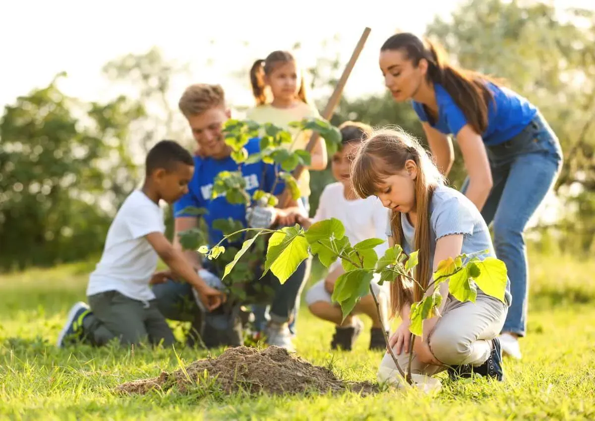 Mutter und Kind pflanzen Baum in einem Garten