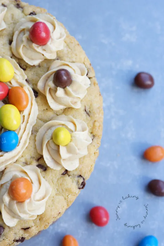 Nahaufnahme der Oberseite eines verrückten Geburtstagskuchens, verziert mit bunten M&amp;Ms und Erdnussbuttercreme-Tupfern.