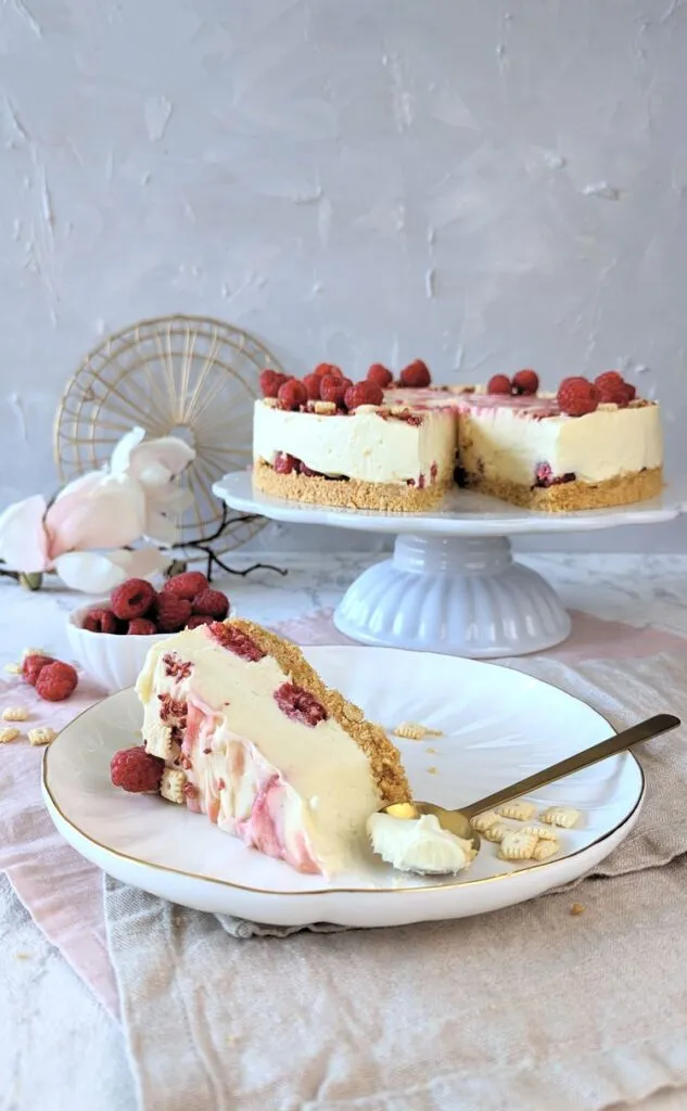 Nahaufnahme des cremigen Belags aus weißer Schokolade und Frischkäse mit eingebetteten Himbeeren.
