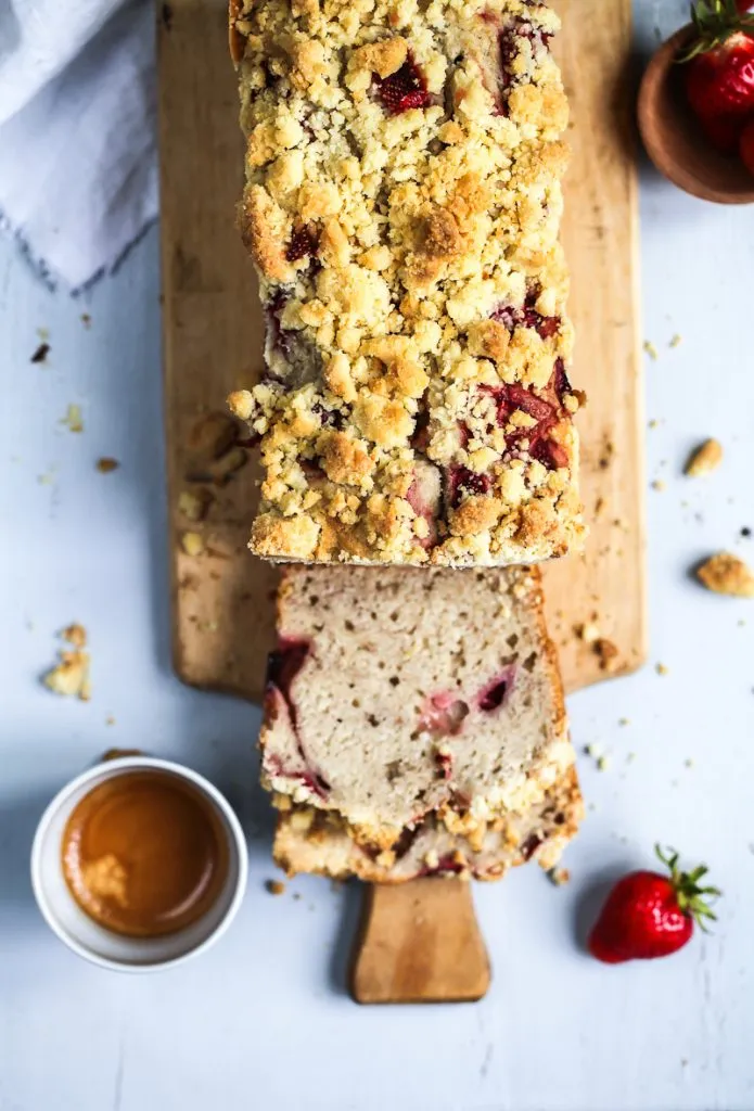 Nahaufnahme des Erdbeer-Bananenbrots mit Puderzucker bestreut, das die Textur der Streusel und die Frische der Erdbeeren betont. Eine süße Belohnung.