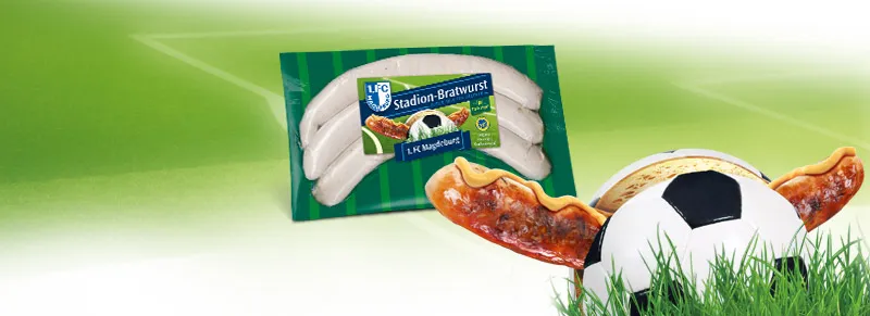 Nahaufnahme einer fertig gegrillten Stadionwurst im knusprigen Brötchen mit Senf