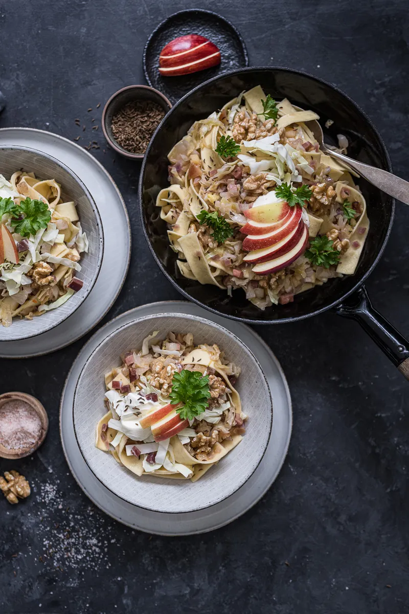 Nahaufnahme einer Krautfleckerl Pfanne mit gebratenem Spitzkohl, Nudeln und Speck, bereit zum Servieren