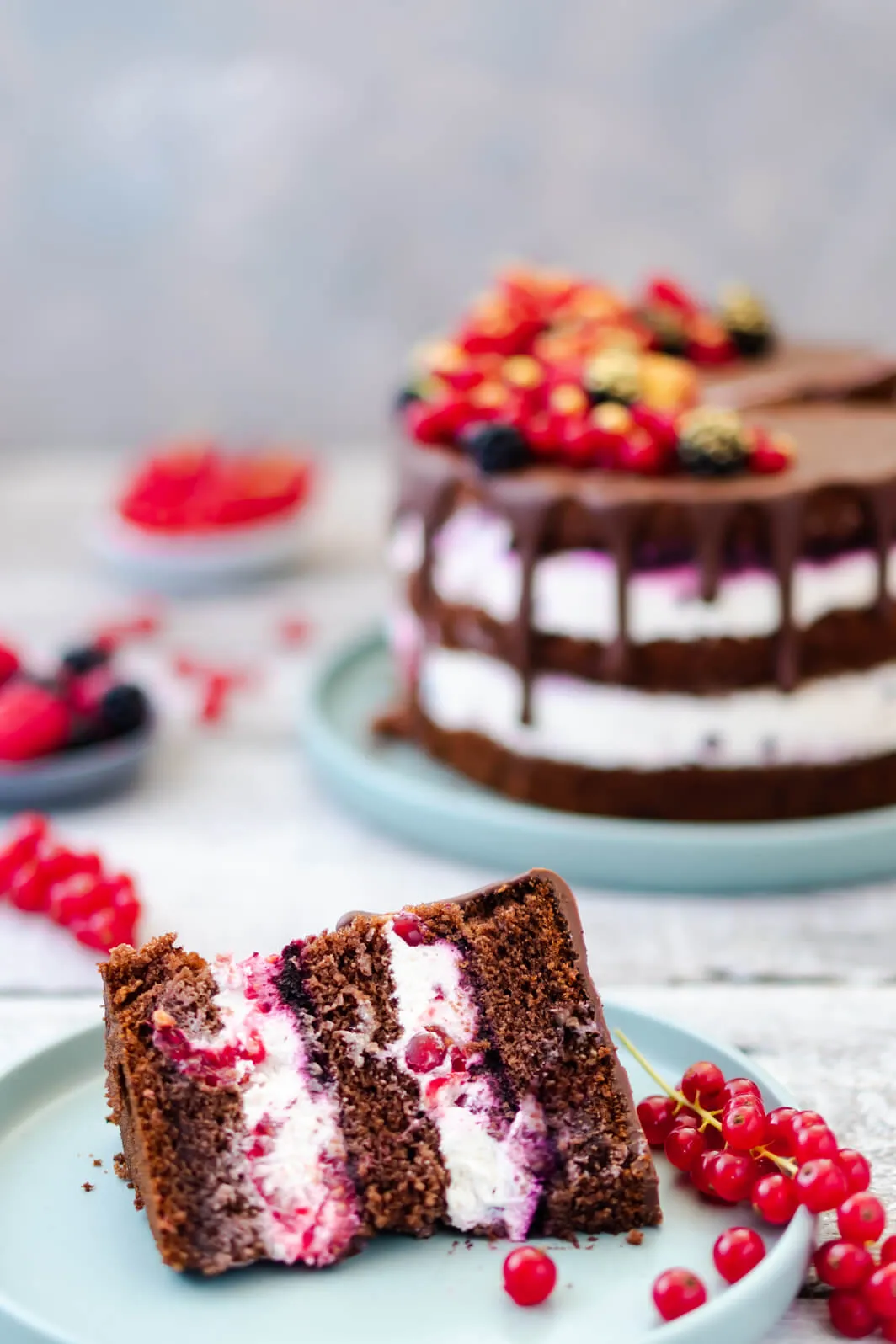 Nahaufnahme einer mehrstöckigen Beerentorte, die ihren reichhaltigen Schokoboden und die cremige Beerenfüllung zeigt.