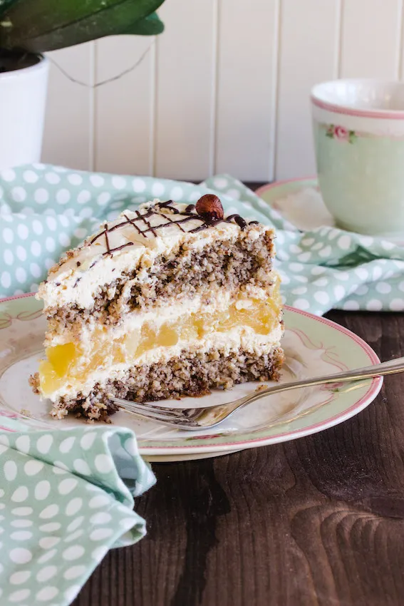 Nahaufnahme einer Scheibe glutenfreier Apfel-Nuss-Sahne-Torte mit Apfelkompott