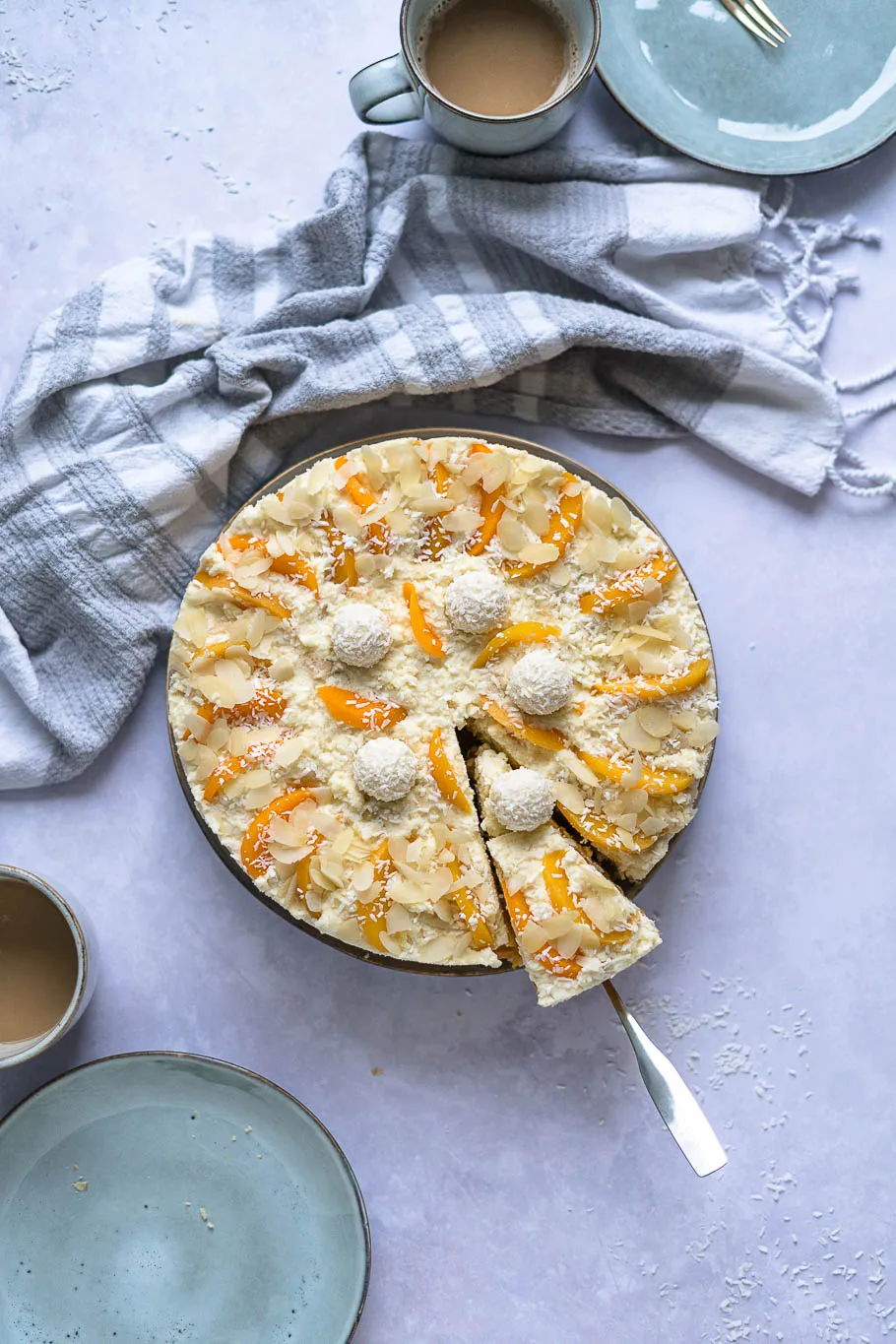 Nahaufnahme einer Scheibe Pfirsich-Maracuja-Raffaelo-Torte mit Schichten aus Kokosboden und Sahnecreme