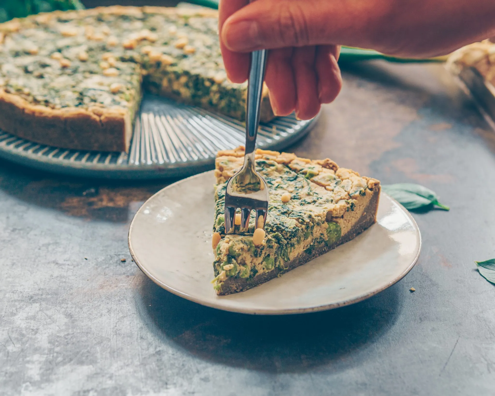 Nahaufnahme einer veganen Spinat Quiche mit knusprigem Teff-Boden
