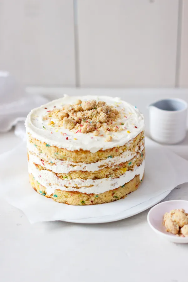 Nahaufnahme eines Funfetti Schichtkuchens mit bunten Streuseln und weißem Frosting