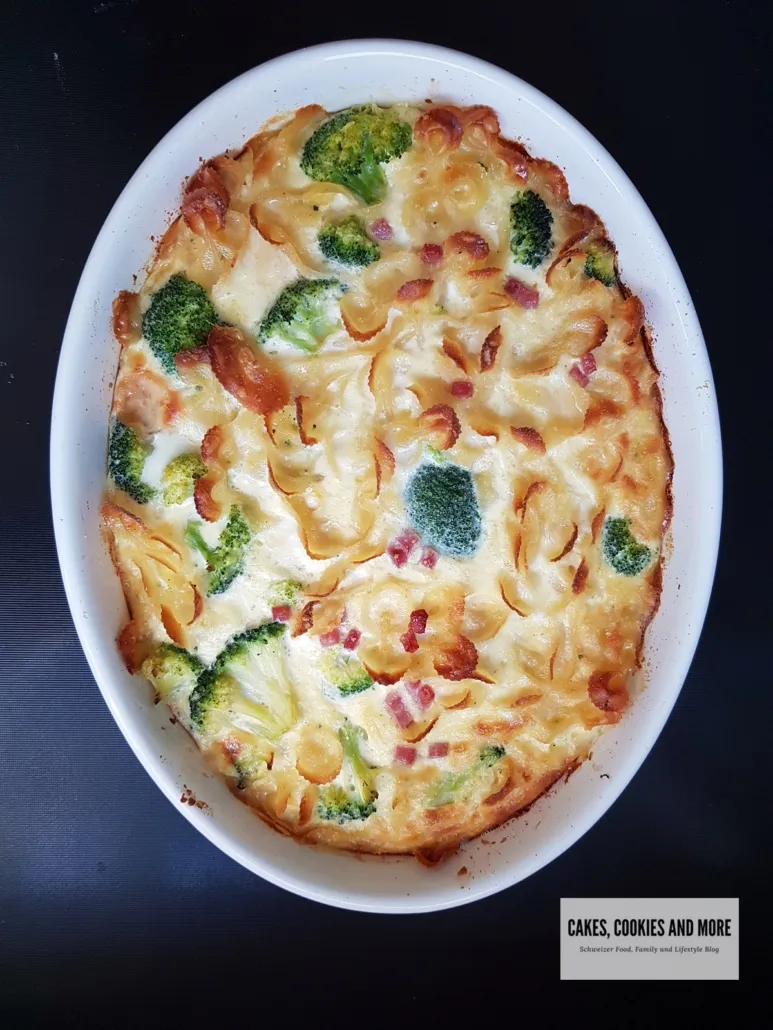 Nahaufnahme eines köstlichen Teigwaren-Auflaufs in einer Gratinform, mit geschmolzenem Käse und Kräutern garniert.