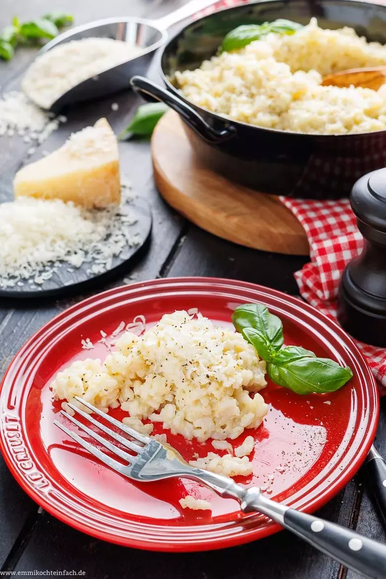 Nahaufnahme eines Löffels, der cremiges Risotto aus einem Topf hebt