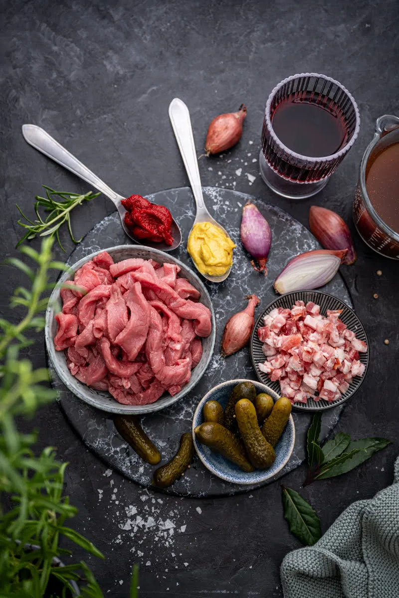 Nahaufnahme eines Rouladentopfs mit zartem Fleisch und reichhaltiger Soße, serviert mit Brot – ein herzhafter Silvester-Genuss