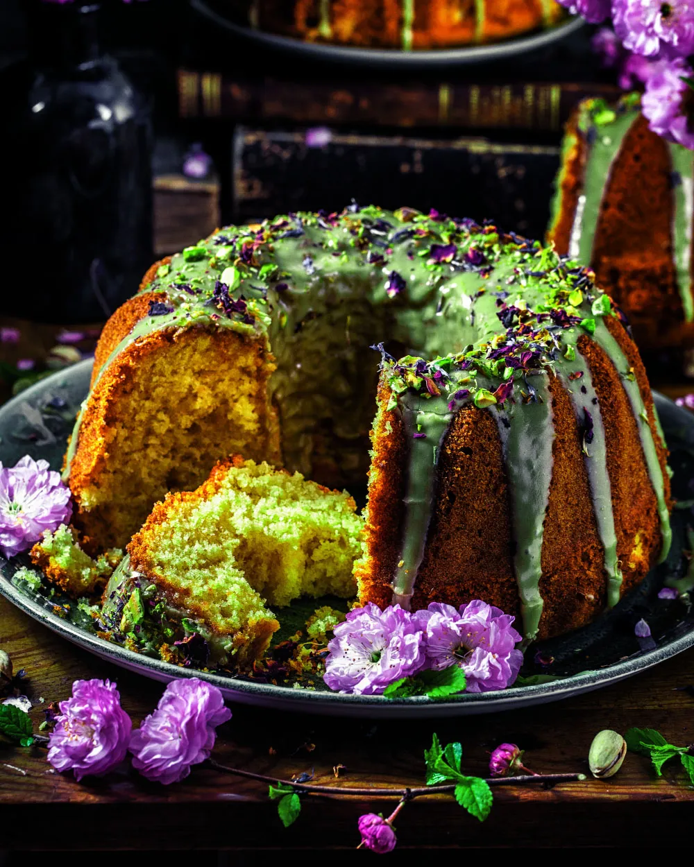 Nahaufnahme eines saftigen Marzipan-Rührkuchens für Ostern, reichhaltig glasiert mit Pistazie und bestreut mit gehackten Nüssen