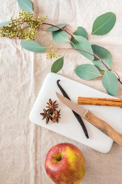 Nahaufnahme eines verlockenden Bratapfelpunschs, bereit zum Servieren, mit flüssiger Sahne.