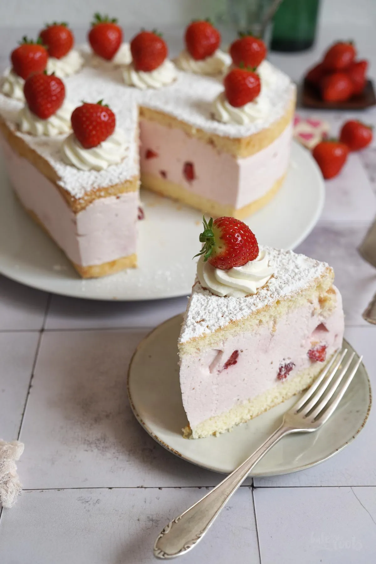 Nahaufnahme: Erdbeeren und Biskuitboden für Käse Sahne Torte in Herzform