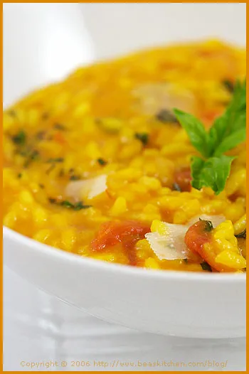 Nahaufnahme von cremigem Safran Risotto mit frischem Basilikum und Parmesan