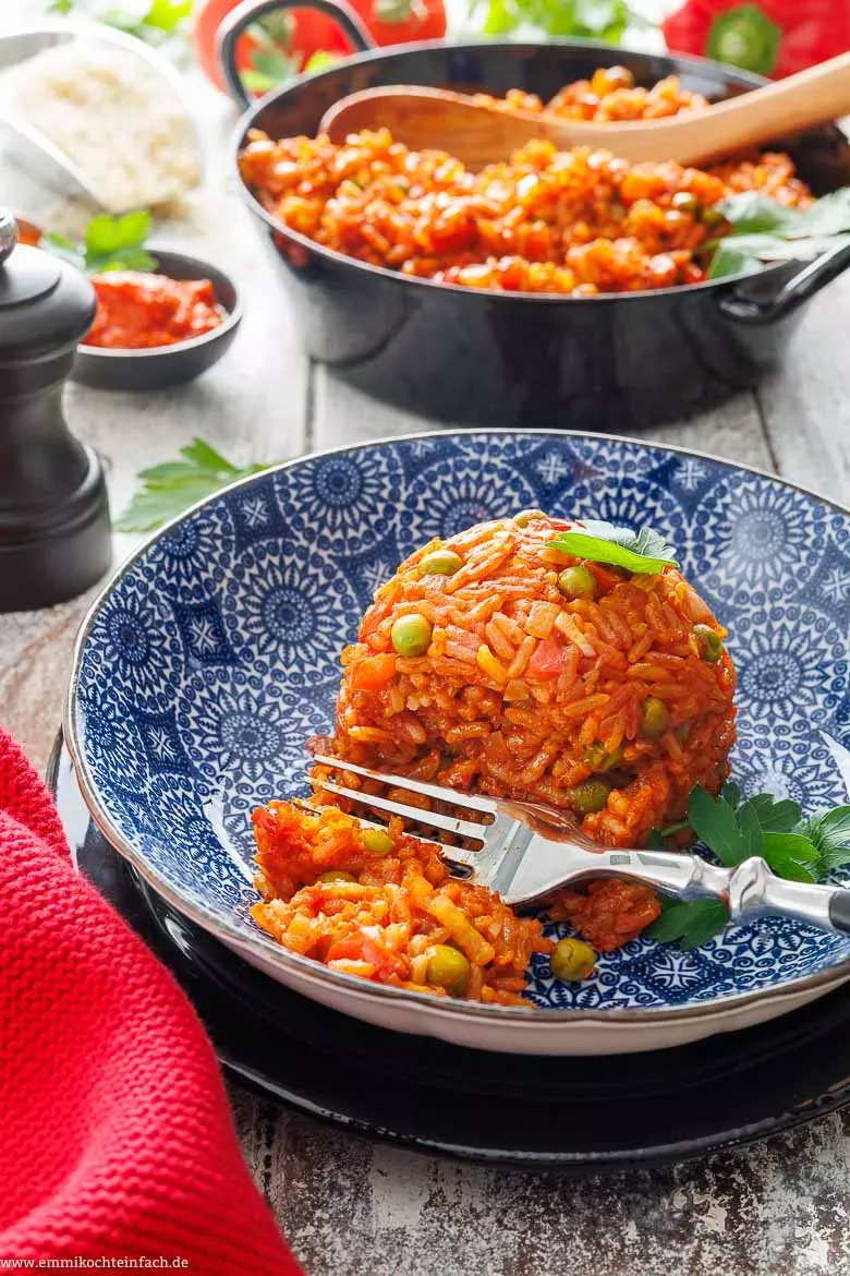 Nahaufnahme von Djuvec Reis in einer tiefen Schale, die bunten Paprika- und Tomatenstücke sowie Erbsen sind deutlich sichtbar.