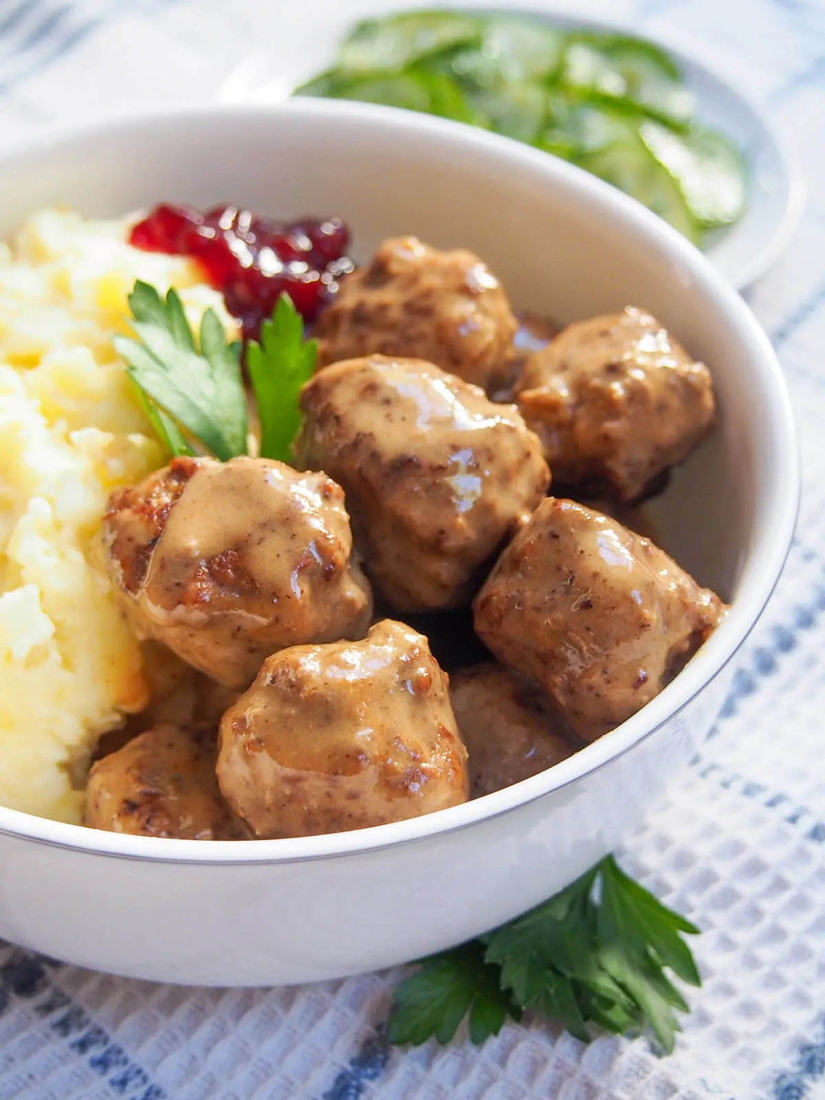 Nahaufnahme von Köttbullar in Sahnesauce mit frischen Preiselbeeren