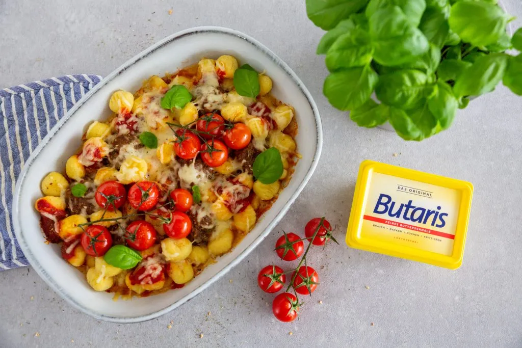 Nahaufnahme von saftigen Hackbällchen im Ofen mit geschmolzenem Käse