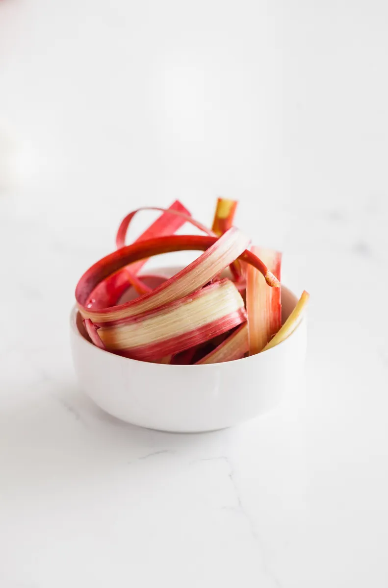 Nahaufnahme von Zutaten für Rhabarber Aperol Spritz: Rhabarber, Zucker und Aperol.