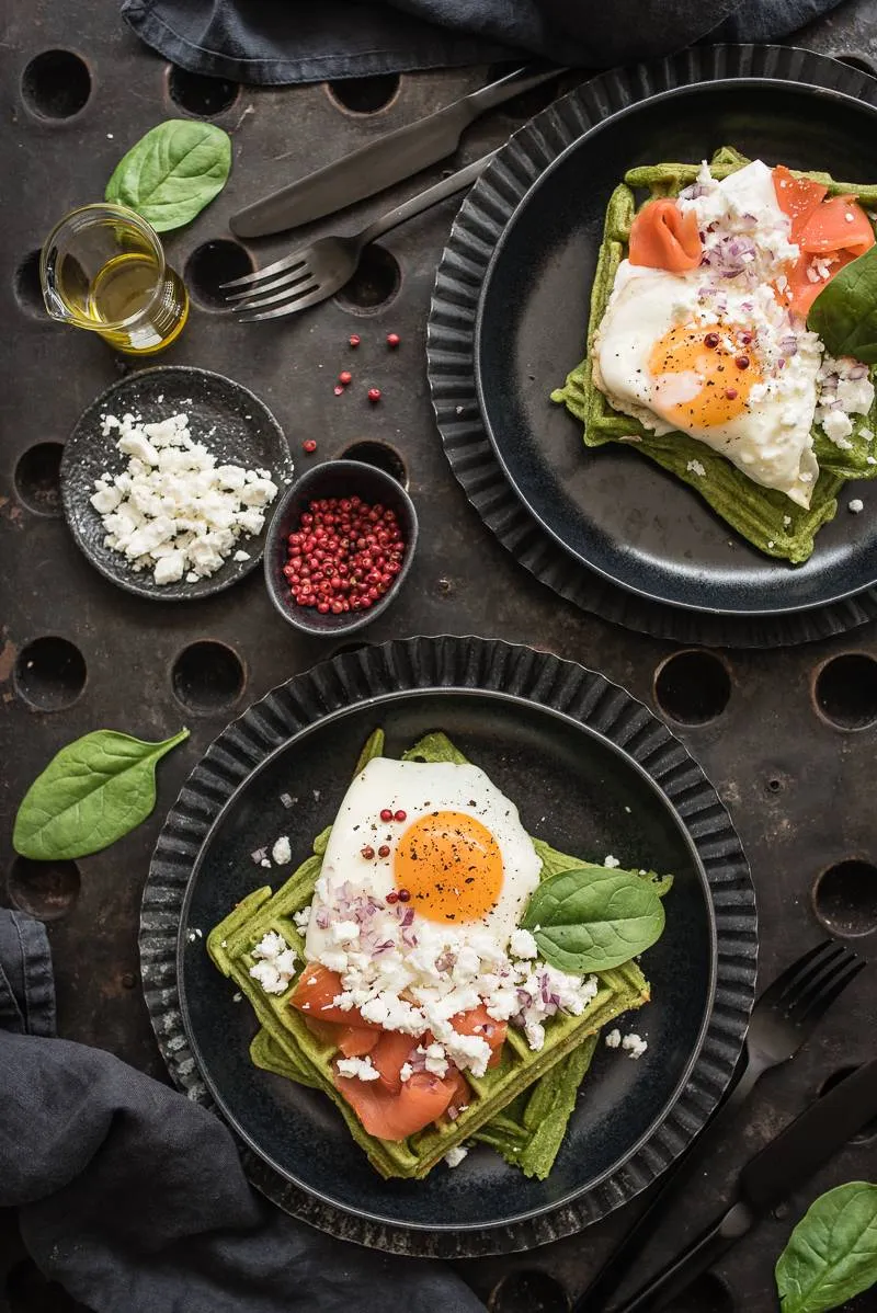 Nahaufnahme von zwei herzhaften Spinatwaffeln mit frischen Toppings, ein beliebtes Gericht mit Schafskäse