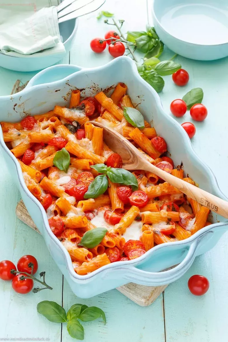 Nudelauflauf mit Tomate und Mozzarella, kurz vor dem Überbacken im Ofen, mit frischen Mozzarella-Stückchen bedeckt.