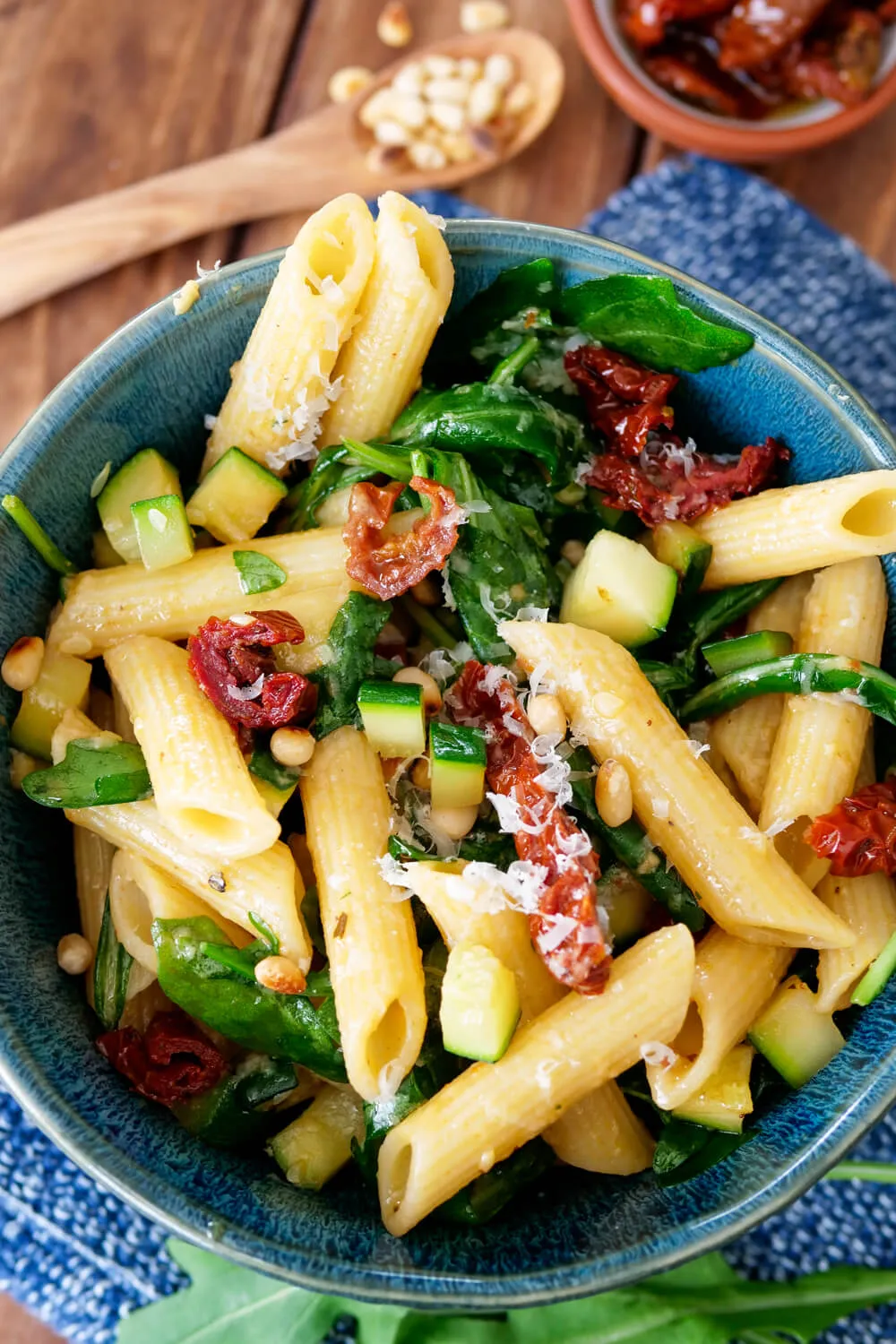 Nudelsalat mit Honig-Senf-Dressing, Rucola, getrockneten Tomaten, Pinienkernen und Zucchini