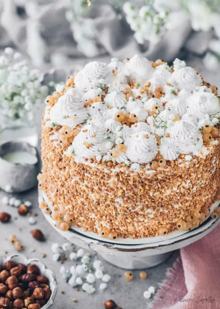 Nuss Sahne Torte mit gehackten Haselnüssen und weißen Johannisbeeren