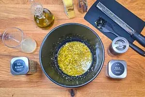 Olivenöl, Zitronensaft und -schale, Honig, Senf, italienische Kräuter, Salz und schwarzen Pfeffer für die Soße verrühren.