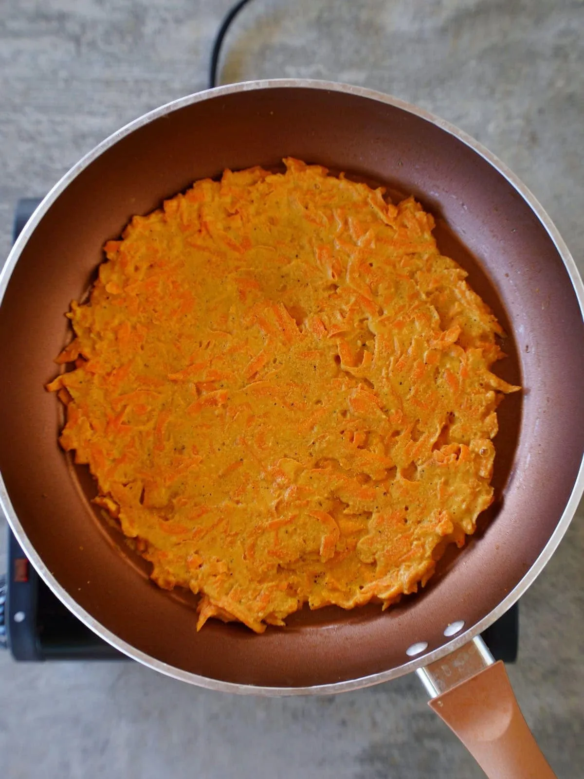 Orangefarbenes Karotten-Omelett in der Pfanne