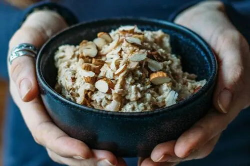 Original Bircher Müsli in einer Schale mit Apfelscheiben und Walnüssen.