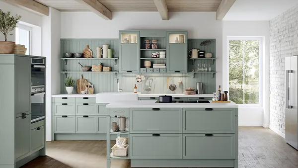 pastellgrüne häcker küche mit kochinsel und weißer arbeitsplatte im landhausstil