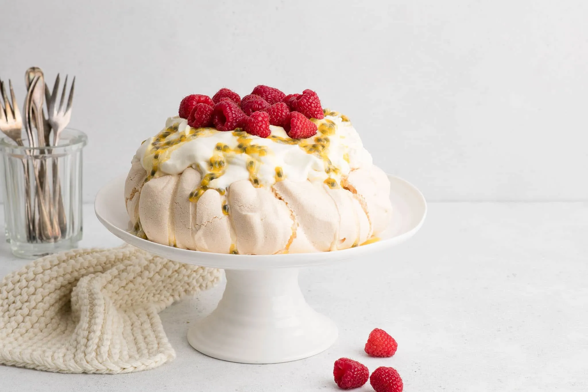 pavlova mit Sahne und Maracuja auf weißem Kuchenständer