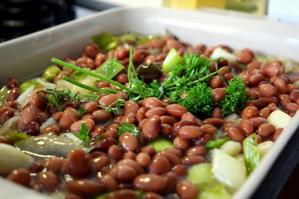 Perfekt gegarte Sous-vide Lammkeule mit französischem Bohnengemüse auf dem Teller