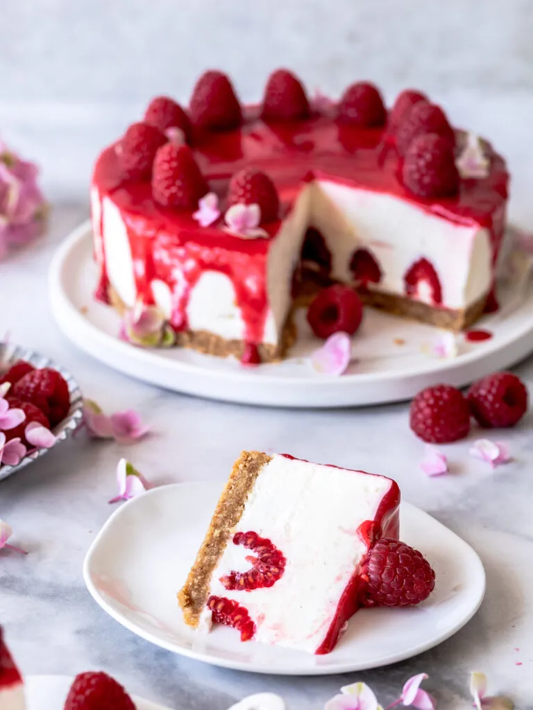 Perfekt geschichtete Joghurt-Sahne-Torte mit Himbeeren und knusprigem Boden, ein ideales No-Bake-Dessert
