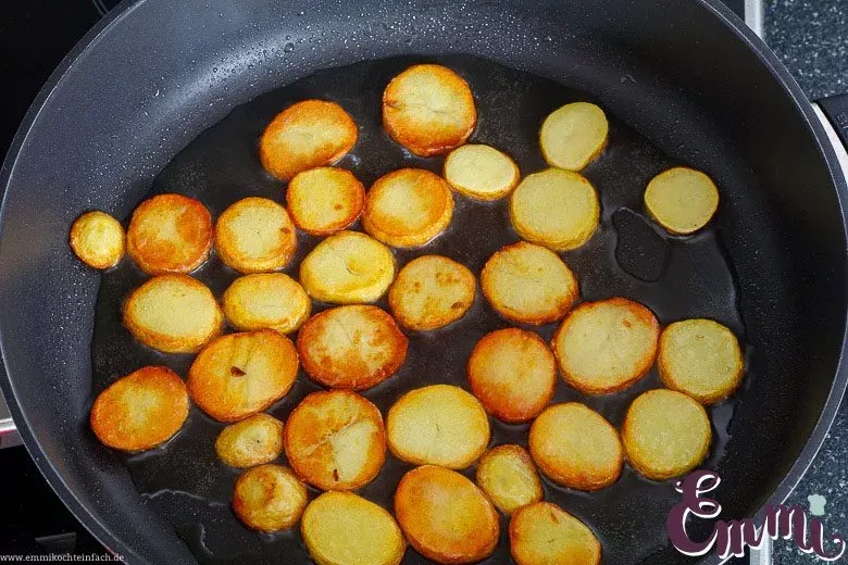 Pfanne mit einer einzelnen Schicht Kartoffelscheiben, bereit zum Braten