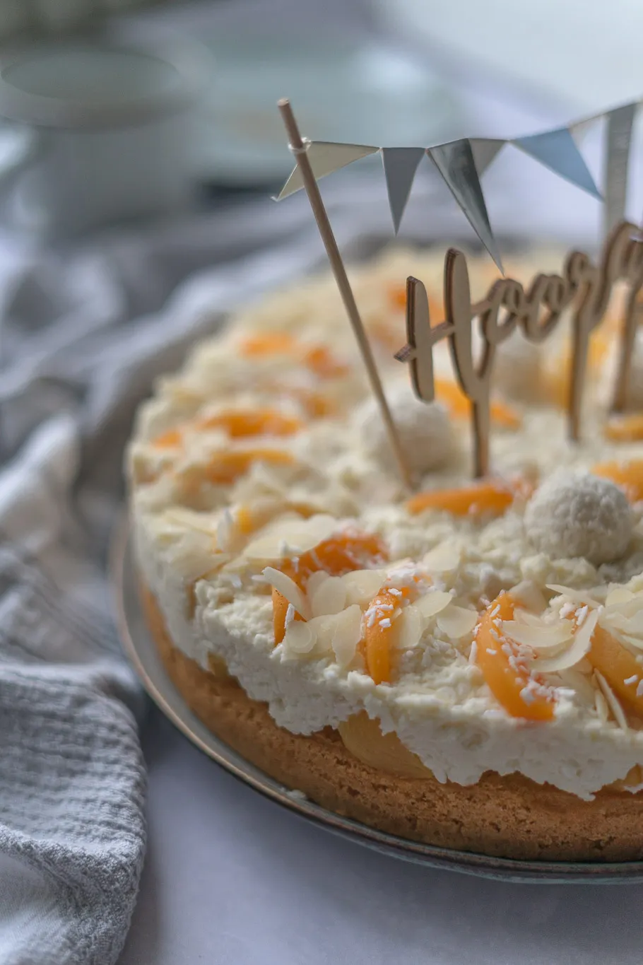 Pfirsich-Maracuja-Raffaelo-Torte, aufgeschnitten, zeigt die cremige Füllung und den fruchtigen Kern