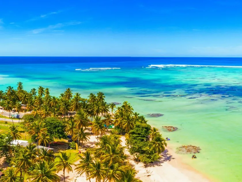 Pigeon Point auf Tobago mit weißen Sandstrand, türkisfarbenem Wasser und ikonischer Strohhütte