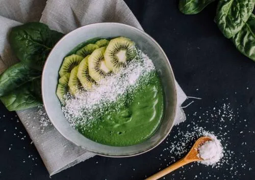 Pistazienmilch Smoothiebowl mit frischen Früchten und Granola als Topping.