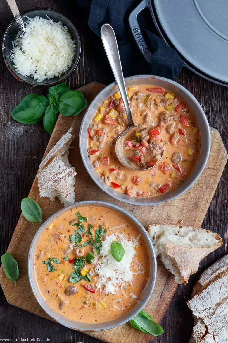 Pizza-Suppe wird mit frisch geriebenem Hartkäse und Basilikum garniert