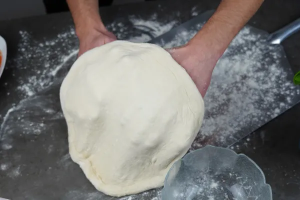 Pizzateig vorsichtig auf die Pizzaschaufel heben