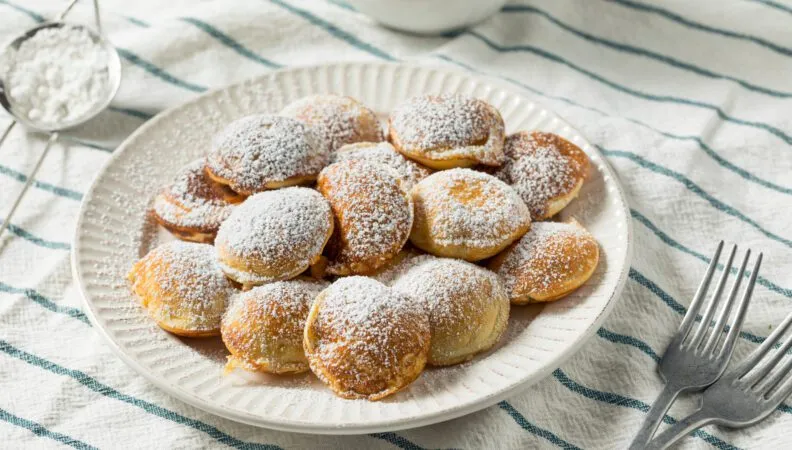 Poffertjes mit Puderzucker und Butter, ein traditioneller niederländischer Snack