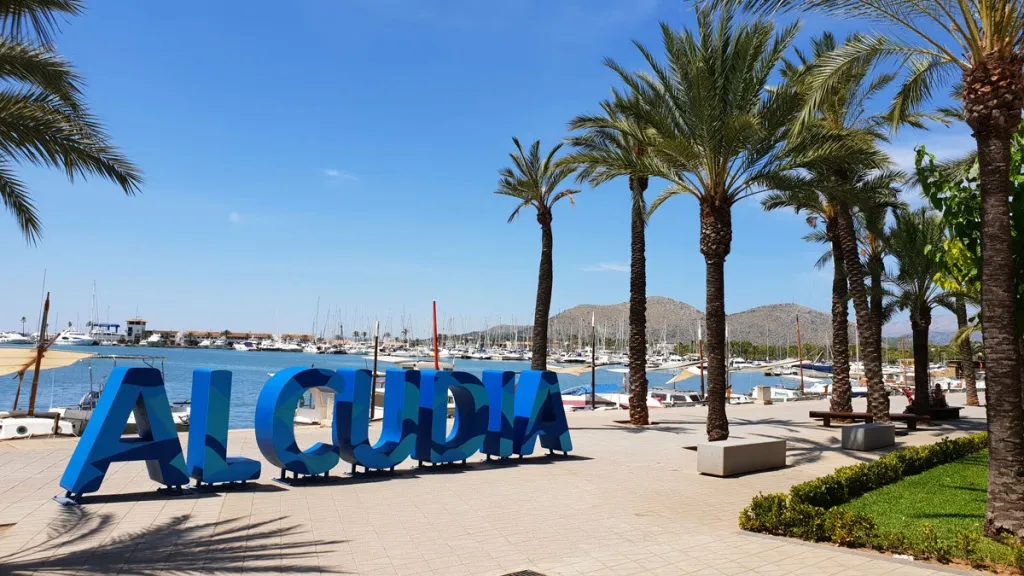 Port d'Alcúdia mit Strand und Booten an der Küste Mallorcas