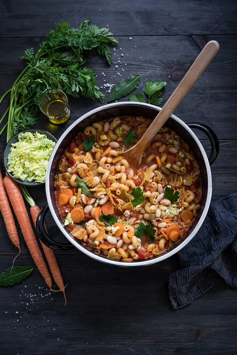Portion der veganen Minestrone mit frischen Kräutern in einer weißen Schale