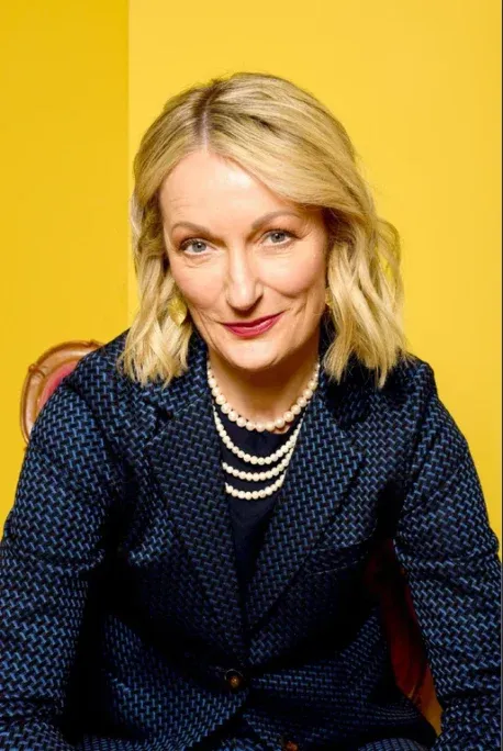 Porträt von Monika Gruber, lächelnd und elegant