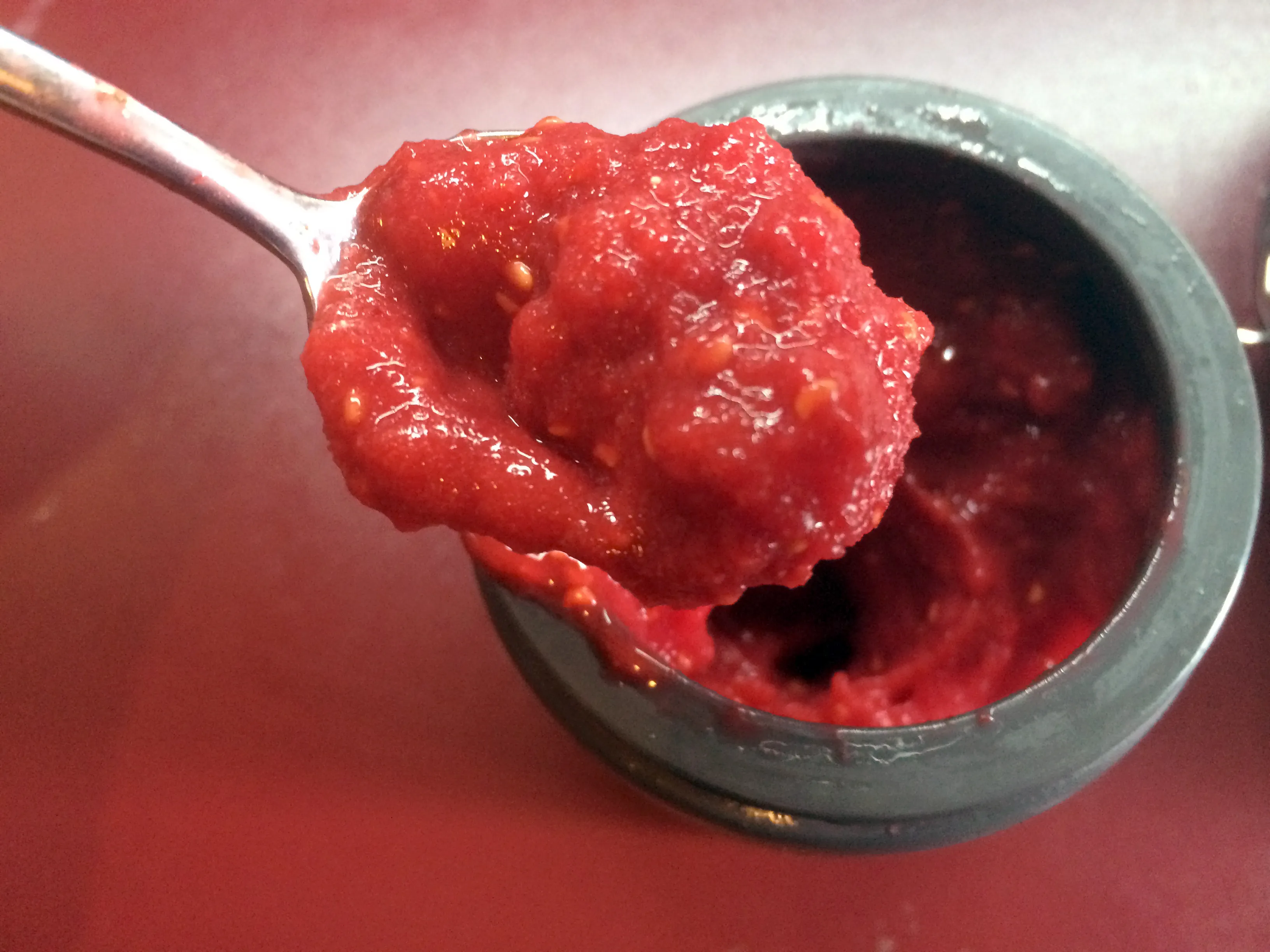 Pürierte Himbeeren als Topping auf dem Kuchen