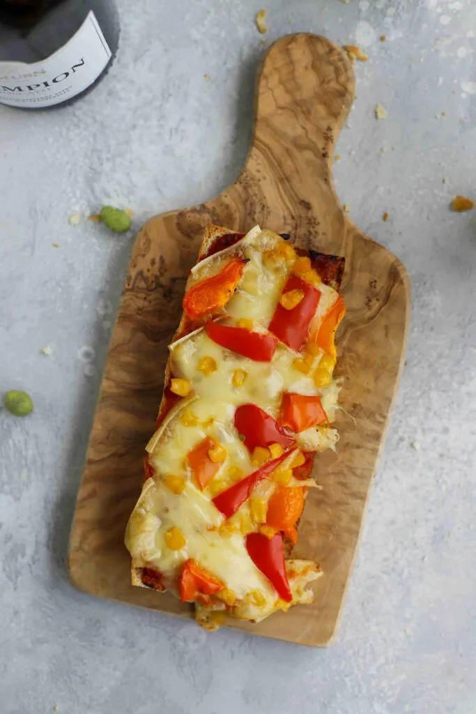 Raclette-Baguette-Vorspeisen auf einem rustikalen Holzbrett